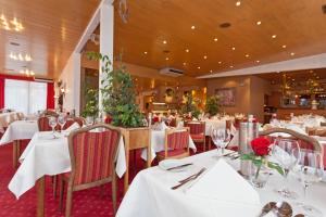 Hotel Hesborner Kuckuck في هالنغبرغ: مطعم بطاولات بيضاء وكراسي عليها ورد