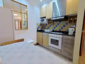 a small kitchen with a stove and a microwave at Flat 1 at 6 Taunton Mews in London
