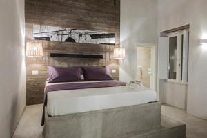 una camera con un grande letto e una parete in legno di BORGOBELTRANI a Trani