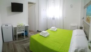 a bedroom with a green bed and a desk at La Bella Vita in San Vito dei Normanni