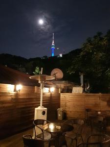 un patio con mesas y sillas por la noche con la luna en Crib 49 Guesthouse - Foreigner only, en Seúl