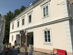 a white building with a woman sitting at a table outside at Apartment Lakeside in Salzburg
