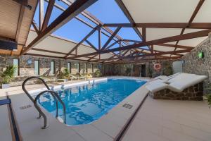 une piscine intérieure avec un plafond en verre et une piscine intérieure dans l'établissement El Caseron de Conil & Spa, à Conil de la Frontera
