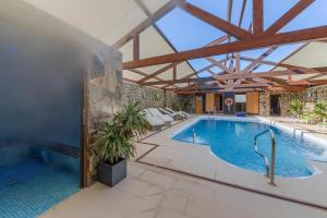 a swimming pool in a house with a building at El Caseron de Conil & Spa in Conil de la Frontera