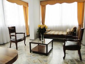 salon z kanapą, krzesłami i stołem w obiekcie ApartaSuites Hotel Montecarlo w mieście Cali