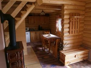 una cucina con stufa a legna in una baita di tronchi di Drevenica Silvia a Liptovský Mikuláš