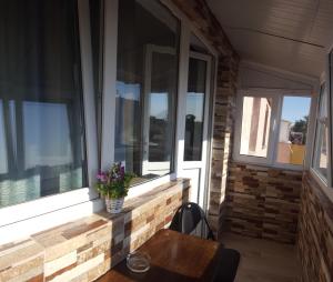 a porch with windows and a bench and flowers at Apartament Lupu - Eforie Nord in Eforie Nord