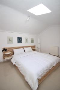 1 dormitorio con 1 cama blanca grande y tragaluz en Amisiana Maisonettes, en Amisianá