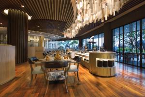 un restaurante con mesas y sillas y una lámpara de araña en Grand Soll Marina Hotel en Tangerang