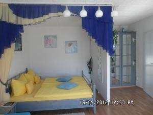a bedroom with a yellow bed with blue pillows at Appartement Sonnenhof in Füssen