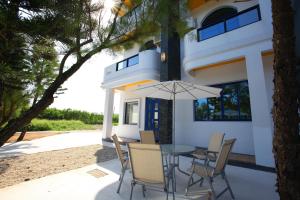 - une table avec des chaises et un parasol en face d'une maison dans l'établissement Easy Stay B&B, à Magong