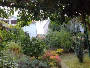 a garden in front of a house with flowers at Apartments Tamara in Sukošan