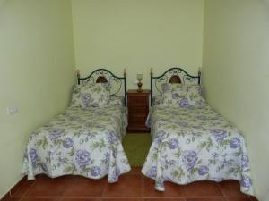 dos camas sentadas una al lado de la otra en un dormitorio en Casa Rural La Fuente, en Trabanca