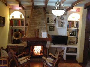 uma sala de estar com lareira e televisão em Casa Rural La Fuente em Trabanca