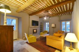 a living room with yellow furniture and a fireplace at Ancien Mas Du Moulin in Eygalières