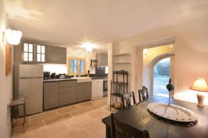 a kitchen and dining room with a table and chairs at Ancien Mas Du Moulin in Eygalières