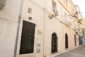 a building with a black door on a street at Antica Dimora B&B Canosa in Canosa di Puglia