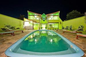 uma grande piscina em frente a uma casa em Pousada Luz do Sol em Rio das Ostras