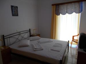 una camera da letto con un letto con lenzuola bianche e una finestra di Helios&Thalassa Rooms a Loutra Edipsou