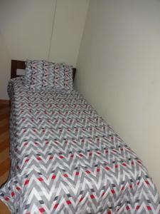 a bed in the corner of a room at Apartamento São Vicente in São Vicente