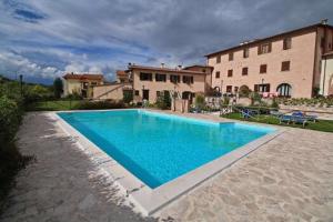 a large blue swimming pool in front of a building at Residence IL PODERE in Piobbico