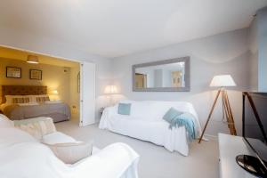 a white bedroom with two beds and a mirror at Putney 1 Bed Apartment by BaseToGo in London