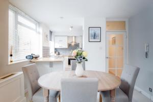 a kitchen with a table with a vase of flowers on it at Putney 1 Bed Apartment by BaseToGo in London
