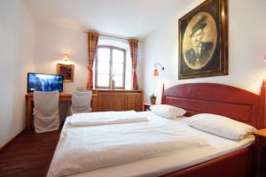 a bedroom with a bed and a desk at Landhotel & Gasthof Baiernrain in Baiernrain