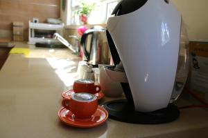 a coffee maker and two cups on a counter at Carmel Mul Yum in Haifa