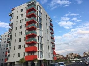 ein hohes weißes Gebäude mit roten Balkonen darauf in der Unterkunft Riverside-Modern apartment-ARED in Oradea