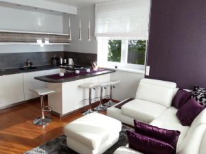 a living room with a white couch and a kitchen at Marcelo Deluxe Apartment in Tihany