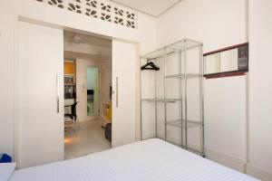 een witte kamer met een glazen deur en een slaapkamer bij Copacabana Frente para a Praia 1005 in Rio de Janeiro