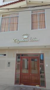 a building with a red door and a sign on it at Hotel Elizabeth Hoss in Sayán