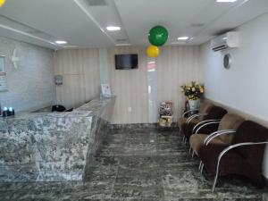 a waiting room with a bunch of chairs and a balloon at Hotel Sao Miguel in Collatina