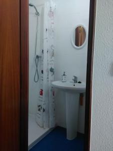 a bathroom with a sink and a shower curtain at Casa Eloy in Setúbal