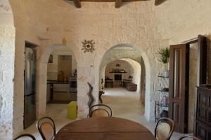 una cucina e una sala da pranzo con tavolo e sedie di Truly Trulli ad Alberobello