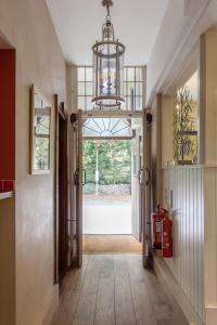 a hallway with a door and a chandelier at The Wychwood Inn in Shipton under Wychwood