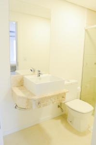 ein Badezimmer mit einem Waschbecken, einem WC und einem Spiegel in der Unterkunft Hotel Vizzion in Paraí
