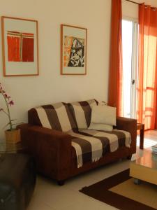 a living room with a brown couch in a room at Vista ao Mar & Lazer Total in Guarujá +104 photos