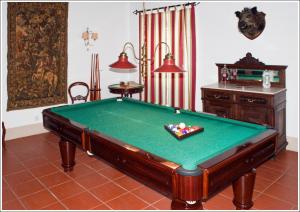 una mesa de billar en una sala de estar con accesorios en Casa d´Alegrete, en Alegrete