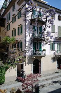 a building with flowering trees in front of it at Locanda di Orta in Orta San Giulio