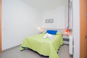 een slaapkamer met een bed met een groene deken en blauwe kussens bij EnjoyGranada GRAN VIA 1B & Parking opcional in Granada
