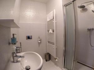 a white bathroom with a sink and a shower at Penzion U tri statkaru in Dobříš