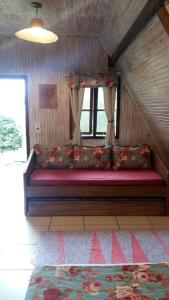 a large red bench in a room with a window at Pousada Aldeias do Paraiso in Monteiro Lobato