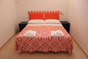 1 dormitorio con 1 cama con colcha roja y blanca en B&B Solacium, en Matera