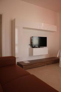 sala de estar con TV de pantalla plana en la pared en B&B Solacium, en Matera