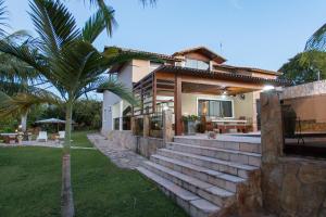 a house with a palm tree in front of it at Casa Colina Pipa in Pipa