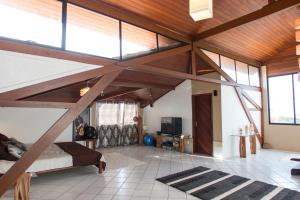 a bedroom with a loft with a bed and large windows at Casa Colina Pipa in Pipa
