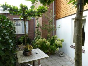 een patio met een houten tafel en een aantal planten bij Hotel het Oude Postkantoor in Brummen