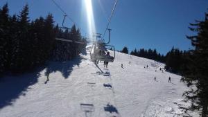 a group of people riding a ski lift on a snow covered slope at Apartment Sofi Yeti in Kopaonik